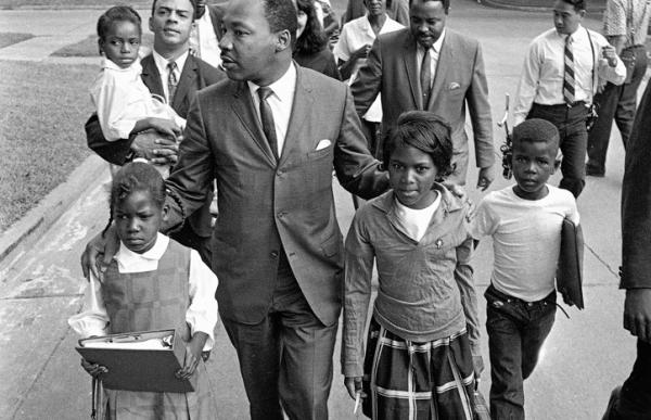 Dr. Martin Luther King Jr. walks with 7-year-old Eva Grace Lemon and Aretha Willis as they march to integrate schools in Grenada, Miss., in 1966. (AP Photo)