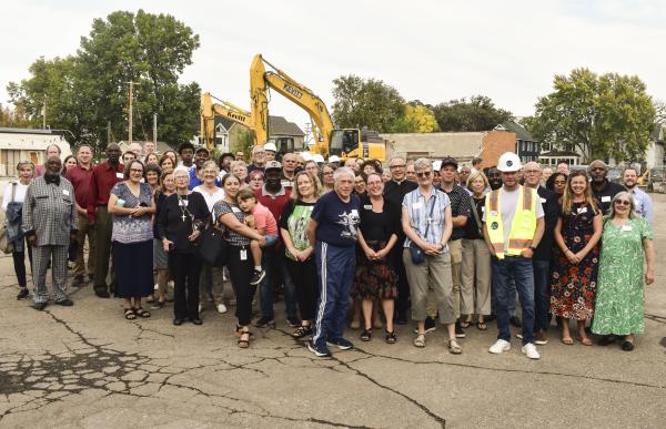 Large group of people stand at a ground breaking for Emerson Village