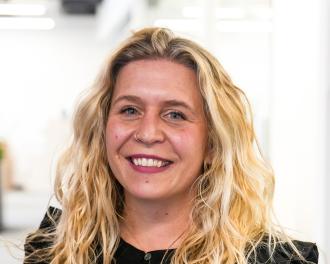 A woman in a black shirt smiles for the camera