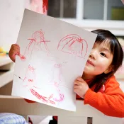 child holding up drawing