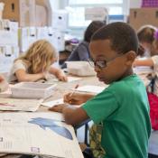 Young students work at desks in a classroom