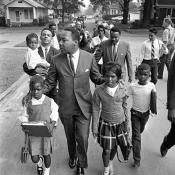 Dr. Martin Luther King Jr. walks with 7-year-old Eva Grace Lemon and Aretha Willis as they march to integrate schools in Grenada, Miss., in 1966. (AP Photo)