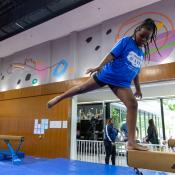 Girl stands on balance beam
