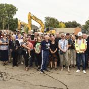 Large group of people stand at a ground breaking for Emerson Village