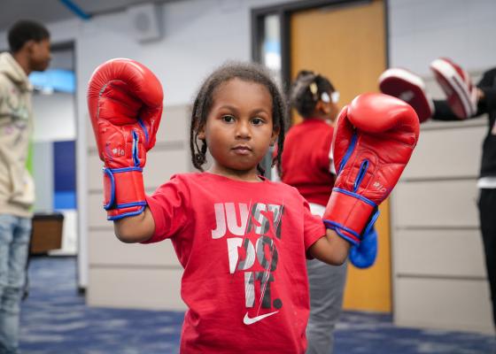 Small child wearing boxing gloves