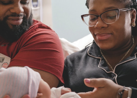 Man and woman look at their new baby