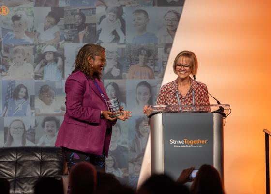 Sondra Samuels stands at a podium accepting an award 
