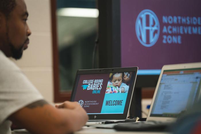 A computer screen showing a presentation in front of a man.