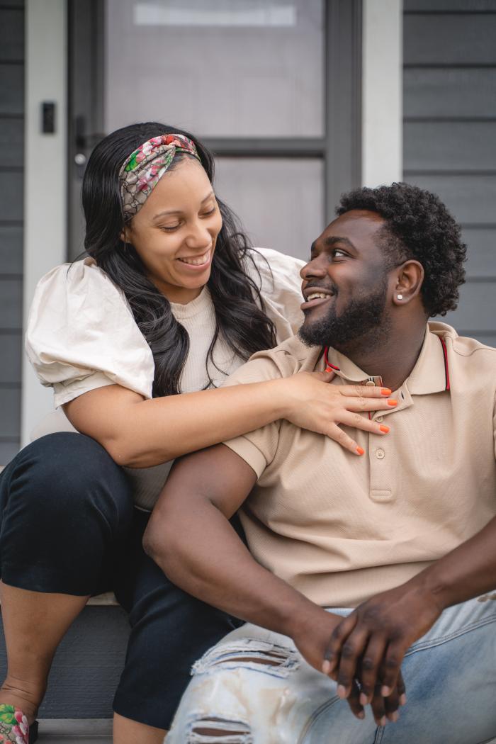 Husband and wife together. Briana and Key look into each other's eyes on the front porch.