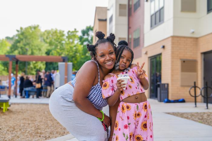 Mother and child smiling in front of Emerson Village